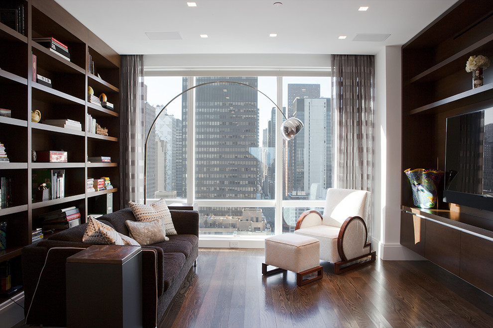 Example of a trendy enclosed dark wood floor family room library design in New York with white walls, no fireplace and a wall-mounted tv