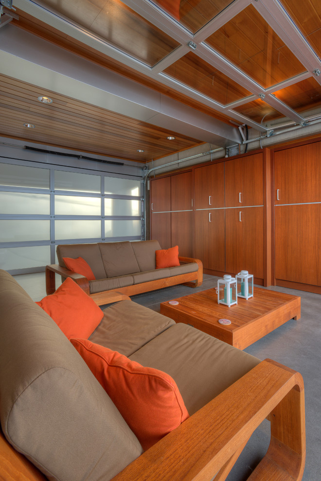 Réalisation d'une petite salle de séjour minimaliste ouverte avec un mur beige, sol en béton ciré, un téléviseur encastré et un sol beige.