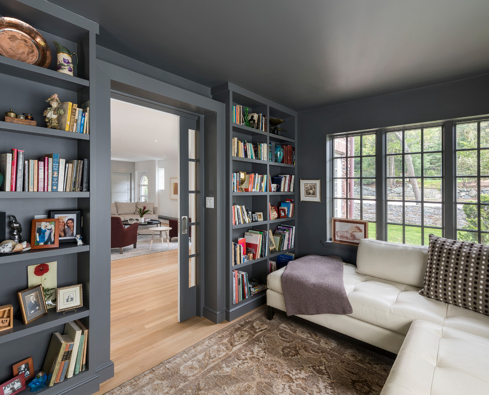 Foto de sala de estar con biblioteca cerrada clásica renovada pequeña con suelo de madera en tonos medios, paredes grises y suelo marrón