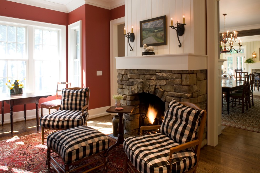 Idee per un soggiorno classico con pareti rosse, parquet chiaro, camino classico e cornice del camino in pietra