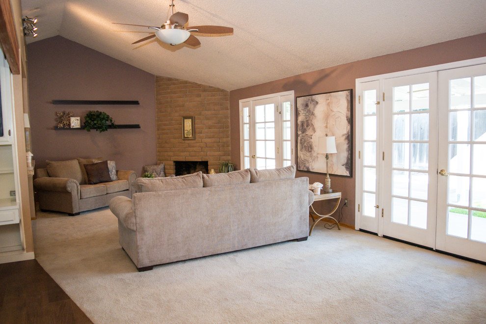 Réalisation d'une grande salle de séjour tradition ouverte avec un mur violet, moquette, une cheminée d'angle, un manteau de cheminée en brique et un sol blanc.