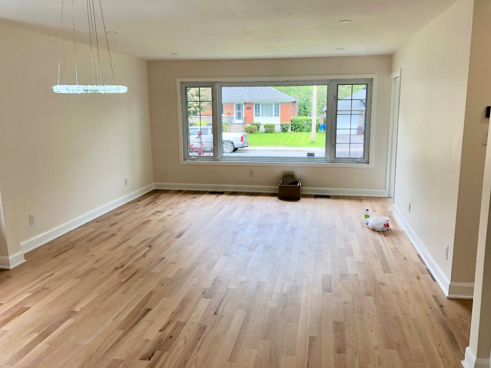 Imagen de sala de estar abierta minimalista de tamaño medio con suelo de madera clara