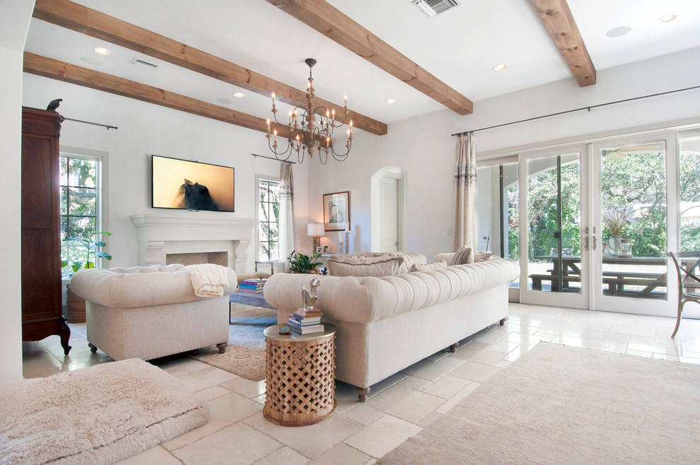 Immagine di un soggiorno mediterraneo di medie dimensioni e chiuso con pareti beige, camino classico e TV a parete