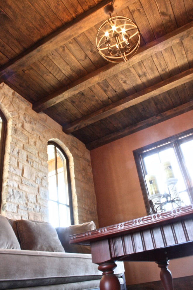 Свежая идея для дизайна: изолированная гостиная комната в средиземноморском стиле с оранжевыми стенами, стандартным камином и с книжными шкафами и полками без телевизора - отличное фото интерьера