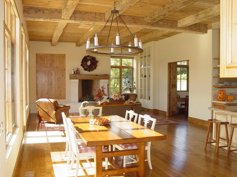 Foto de sala de estar abierta mediterránea con suelo de madera clara y marco de chimenea de yeso