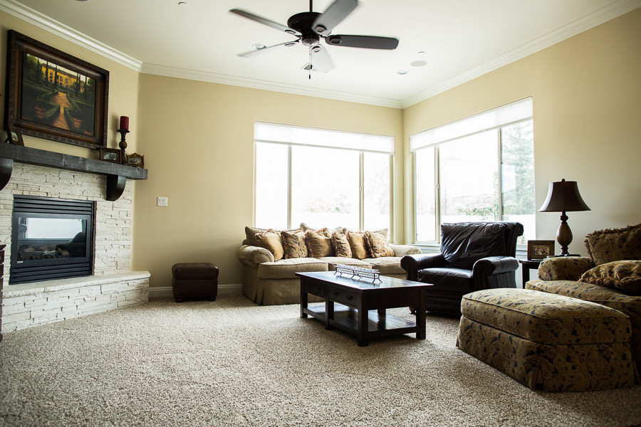 Cette photo montre une grande salle de séjour tendance ouverte avec un mur beige, moquette, une cheminée d'angle et un téléviseur fixé au mur.