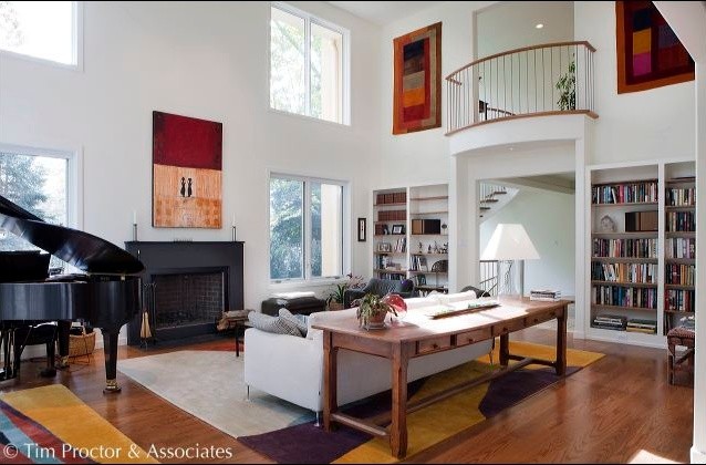 Inspiration for a large contemporary mezzanine games room in Philadelphia with white walls, medium hardwood flooring, a standard fireplace, a metal fireplace surround and brown floors.