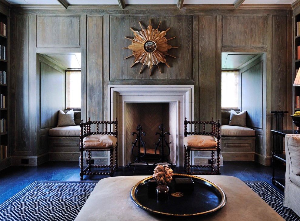 Imagen de sala de estar con biblioteca cerrada tradicional con marco de chimenea de piedra y alfombra