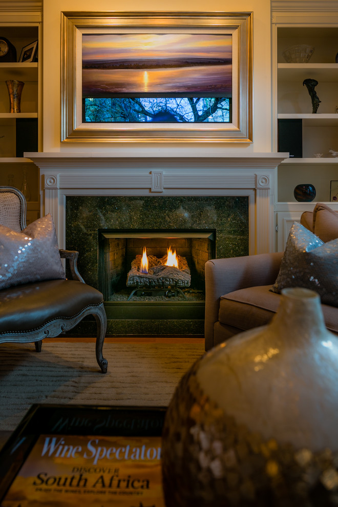 Immagine di un soggiorno chic con pareti beige, parquet chiaro, camino classico, cornice del camino piastrellata e TV nascosta