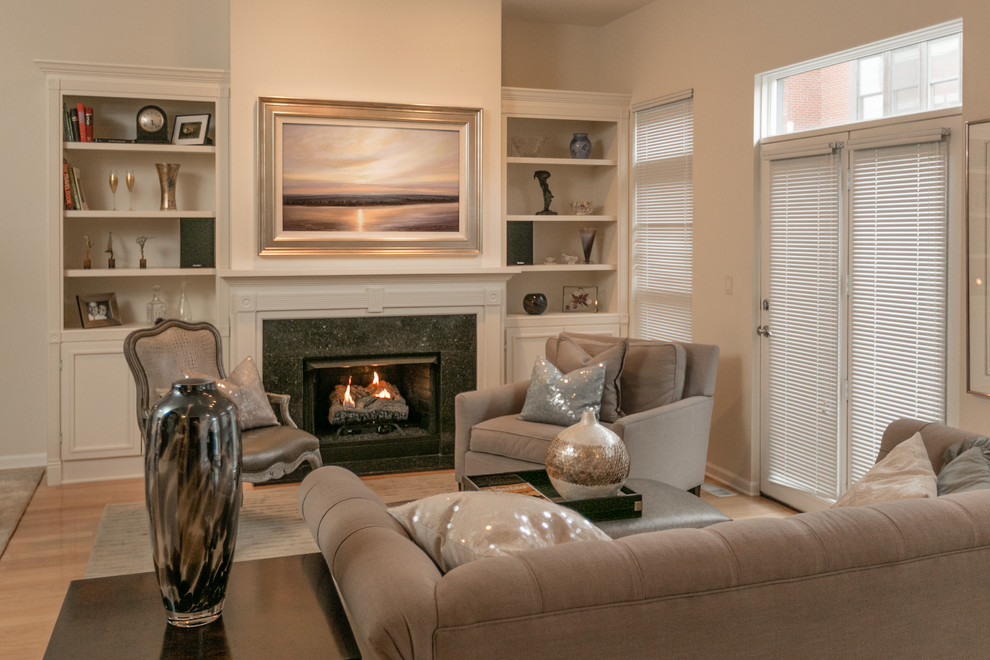 Diseño de sala de estar clásica con paredes beige, suelo de madera clara, todas las chimeneas, marco de chimenea de piedra y televisor retractable
