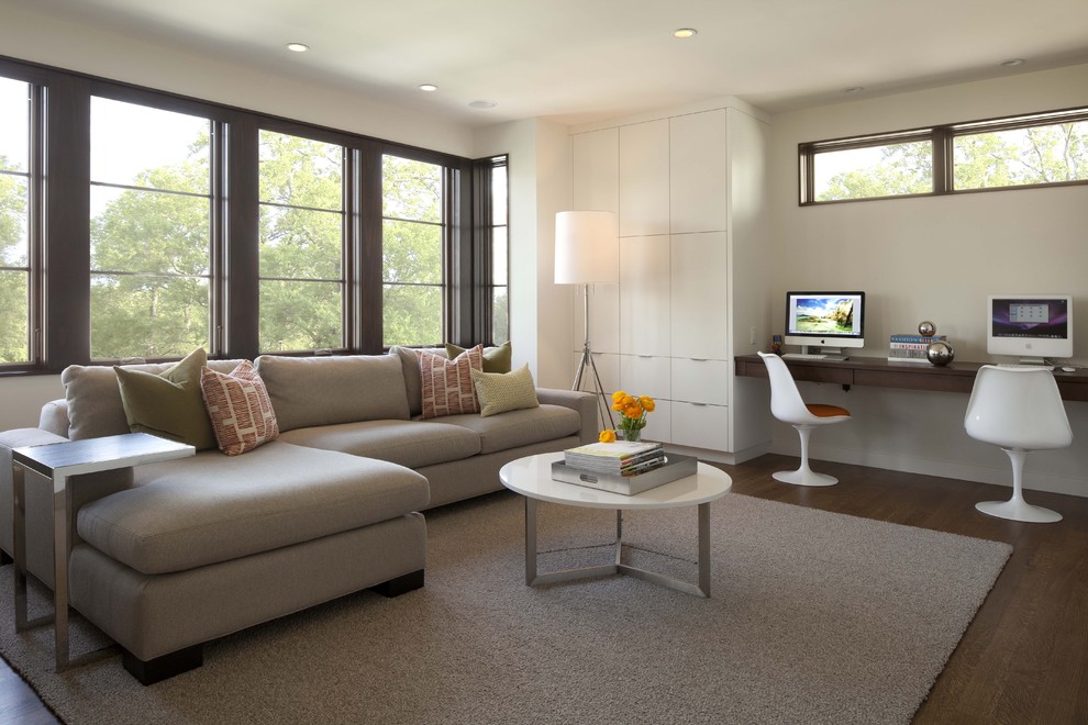 Example of a trendy medium tone wood floor family room design in Minneapolis with beige walls