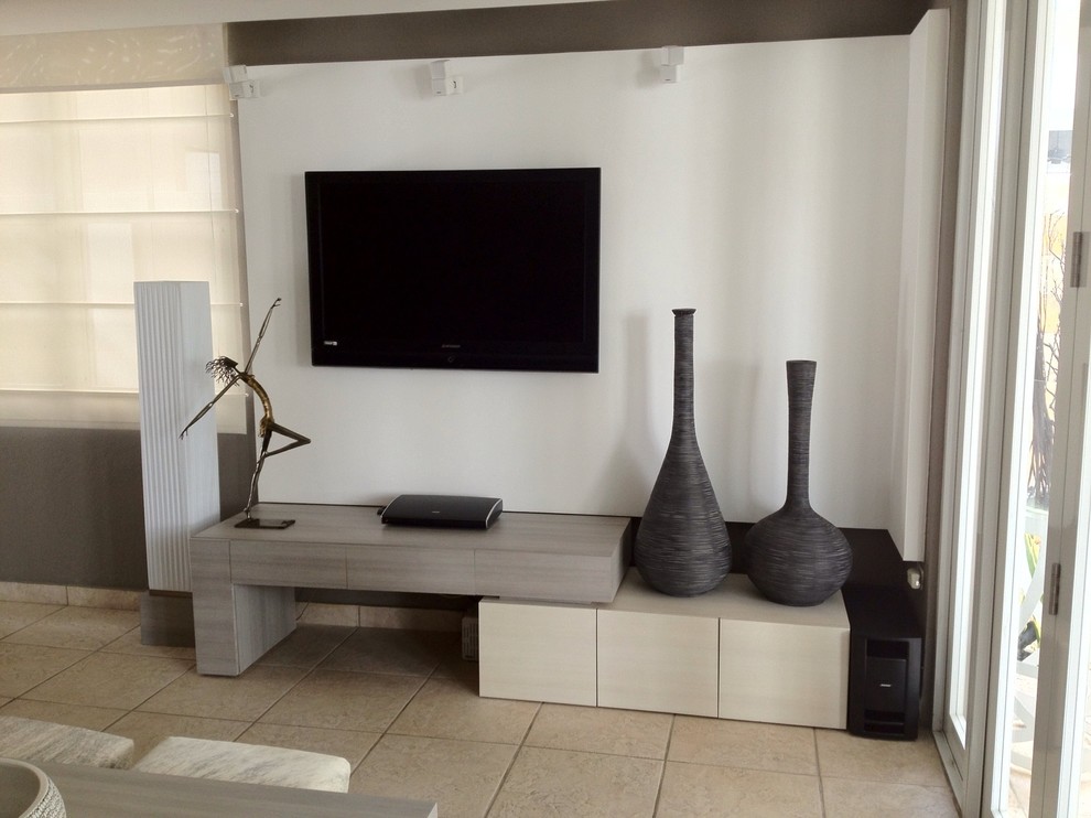 На фото: маленькая открытая гостиная комната в стиле модернизм с белыми стенами, полом из керамогранита и телевизором на стене без камина для на участке и в саду