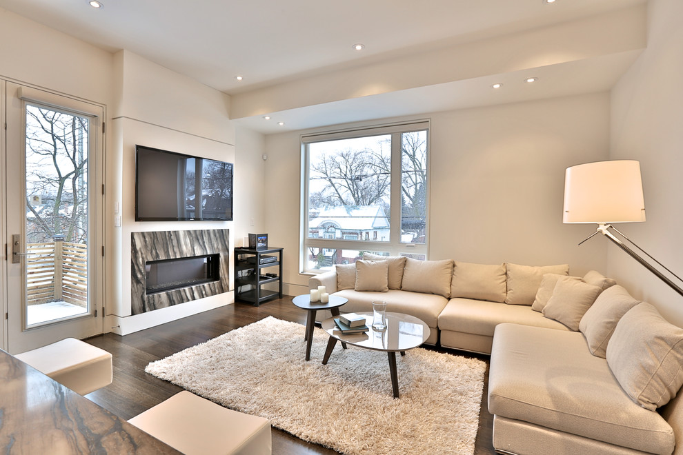 Mittelgroßes, Fernseherloses, Offenes Modernes Wohnzimmer mit beiger Wandfarbe, braunem Holzboden, Kamin und Kaminumrandung aus Stein in Toronto