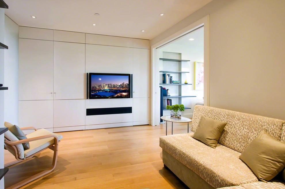 Abgetrenntes Modernes Wohnzimmer mit grauer Wandfarbe, braunem Holzboden und Multimediawand in New York