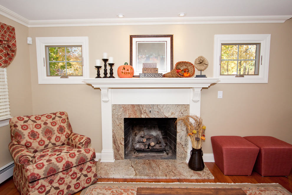 Imagen de sala de estar abierta tradicional con paredes beige, suelo de madera en tonos medios, todas las chimeneas, marco de chimenea de piedra y televisor colgado en la pared
