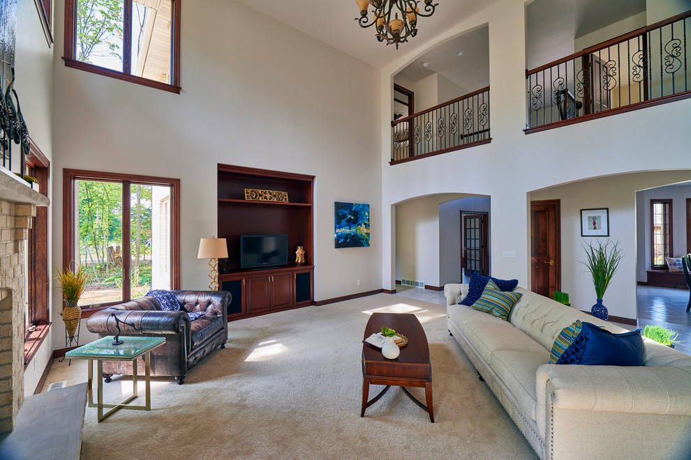 Ejemplo de sala de estar abierta clásica renovada grande con paredes blancas, moqueta, todas las chimeneas, marco de chimenea de ladrillo y pared multimedia