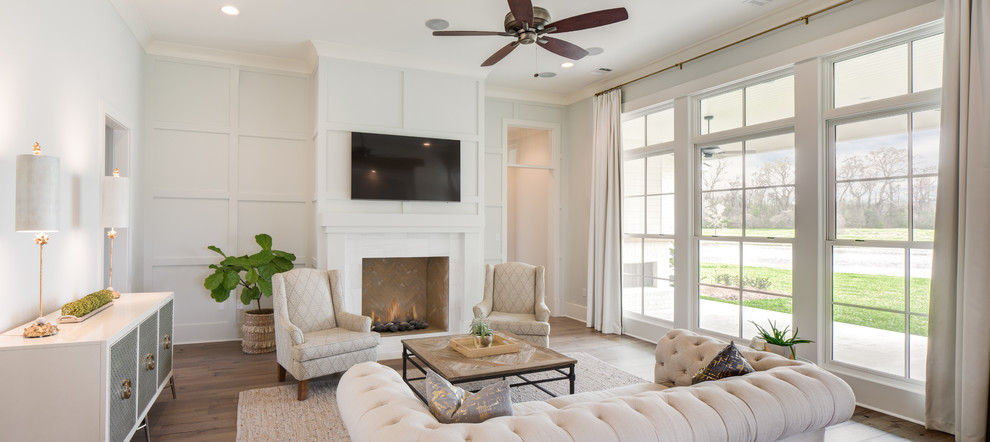 Example of a large transitional open concept light wood floor and brown floor family room design in New Orleans with white walls, a standard fireplace, a brick fireplace and a wall-mounted tv