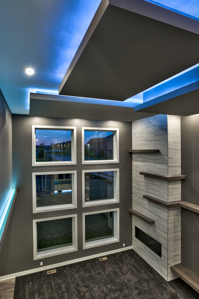 Стильный дизайн: большая открытая гостиная комната в стиле модернизм с серыми стенами, ковровым покрытием, угловым камином, фасадом камина из плитки и телевизором на стене - последний тренд