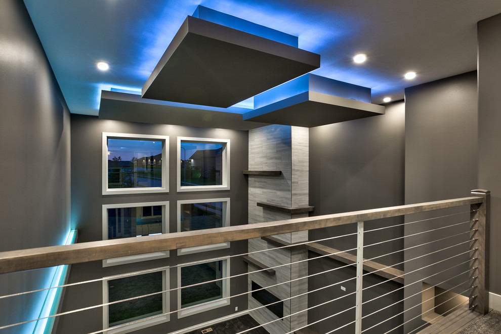 Идея дизайна: большая открытая гостиная комната в стиле модернизм с серыми стенами, ковровым покрытием, угловым камином, фасадом камина из плитки и телевизором на стене