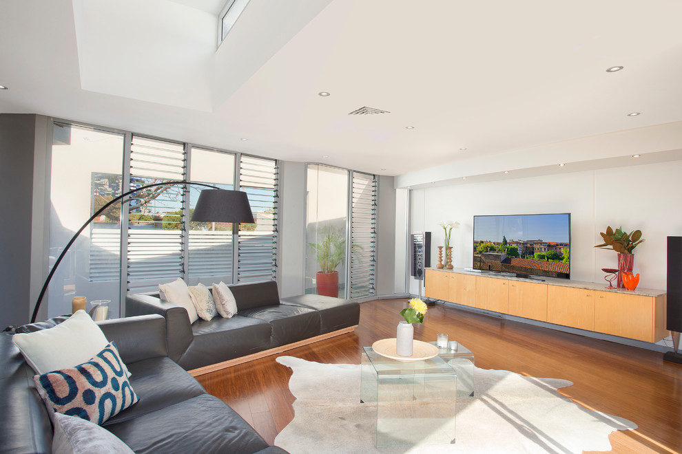 Mittelgroßes, Abgetrenntes Modernes Wohnzimmer ohne Kamin mit weißer Wandfarbe, braunem Holzboden und freistehendem TV in Sydney