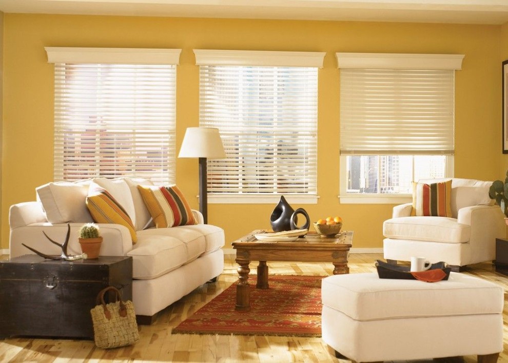 Réalisation d'une salle de séjour ouverte avec un mur jaune, parquet clair et un sol multicolore.