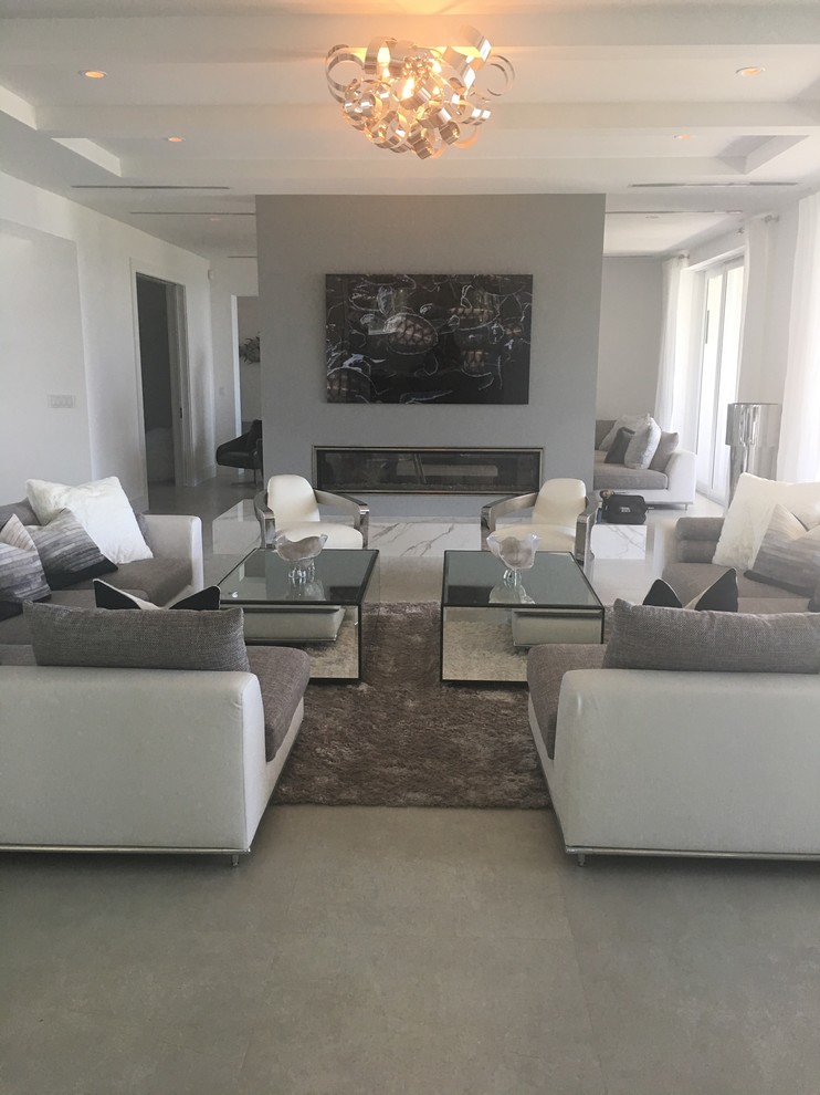 Imagen de sala de estar abierta y blanca contemporánea grande sin televisor y chimenea con paredes blancas, suelo de cemento, suelo gris y vigas vistas
