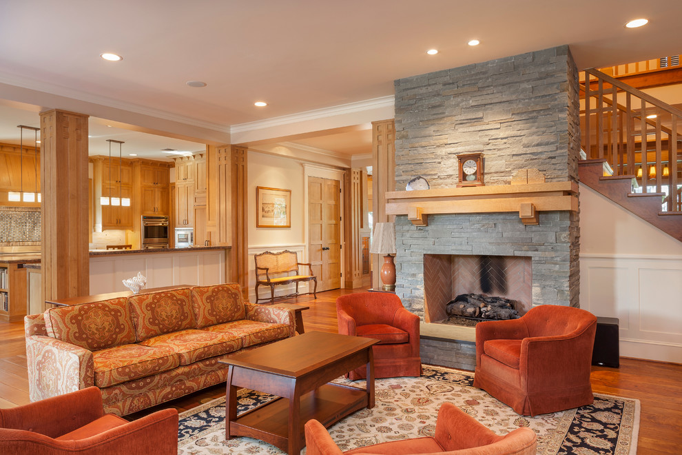 Diseño de sala de estar abierta de estilo americano de tamaño medio con paredes beige, suelo de madera en tonos medios, todas las chimeneas y marco de chimenea de piedra