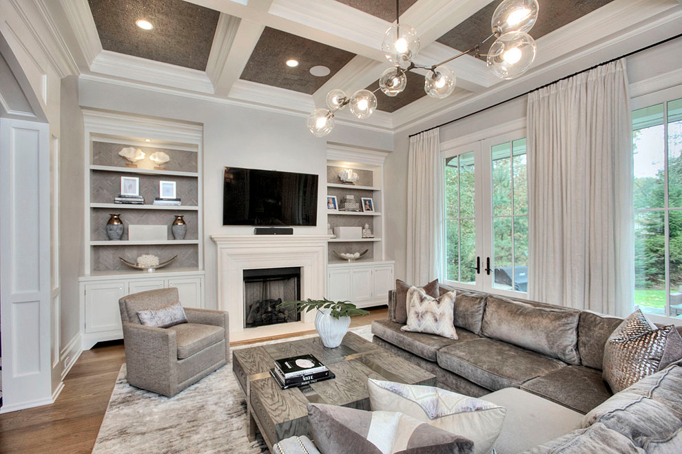 Diseño de sala de estar abierta clásica renovada grande con paredes grises, suelo de madera oscura, todas las chimeneas, marco de chimenea de yeso y suelo marrón