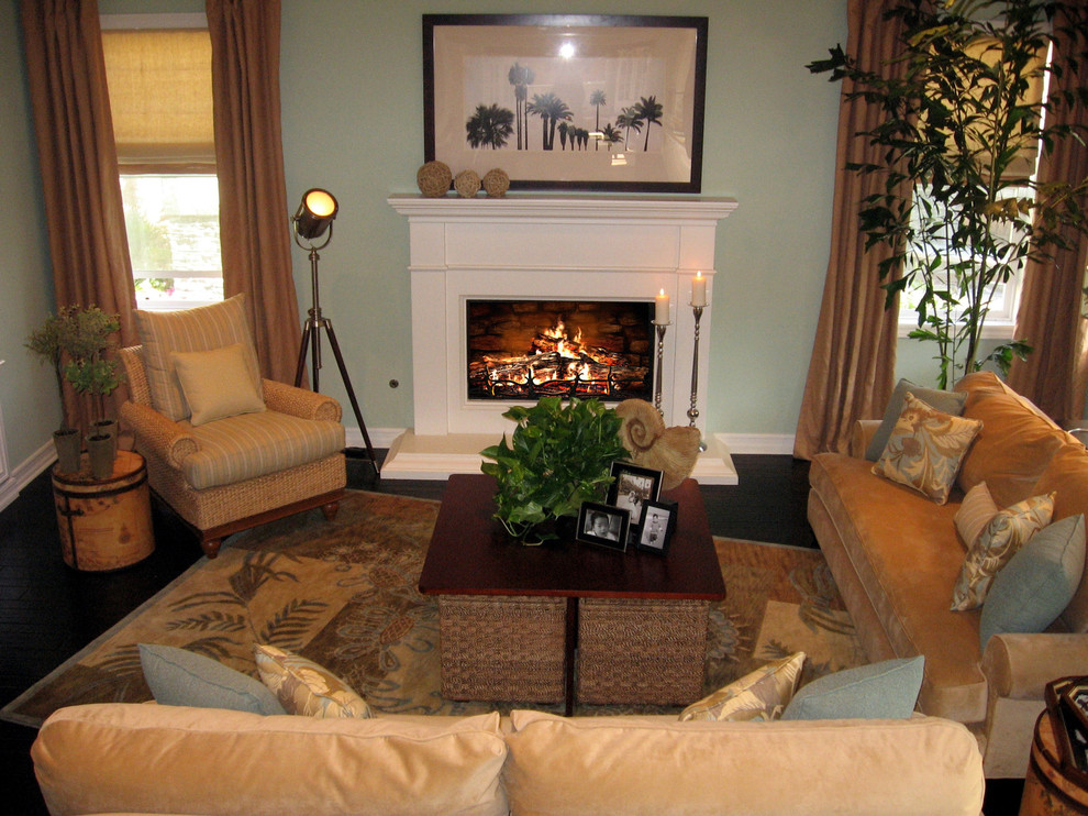 Exemple d'une salle de séjour exotique de taille moyenne et ouverte avec un mur vert, parquet foncé, une cheminée standard et un manteau de cheminée en bois.