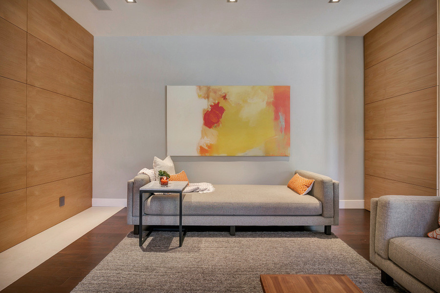 Diseño de sala de estar abierta moderna grande con paredes grises, suelo de madera oscura, todas las chimeneas, marco de chimenea de piedra y televisor colgado en la pared