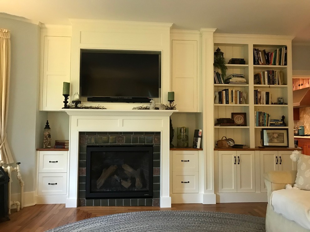 Diseño de sala de estar clásica renovada de tamaño medio con paredes grises, suelo de madera en tonos medios, todas las chimeneas, marco de chimenea de baldosas y/o azulejos, pared multimedia y suelo marrón