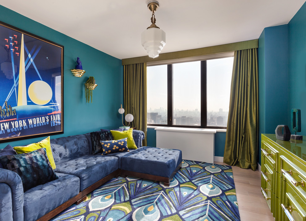 На фото: гостиная комната в современном стиле с синими стенами, светлым паркетным полом и синим диваном без камина