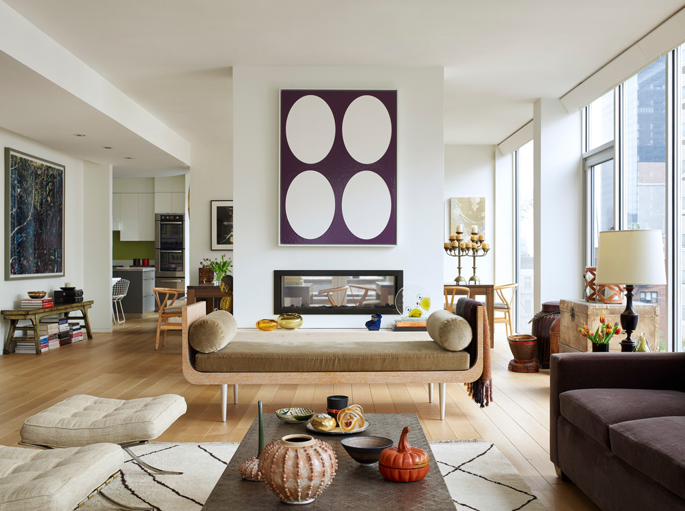 Photo of a contemporary open concept living room in New York with a two-sided fireplace and no tv.