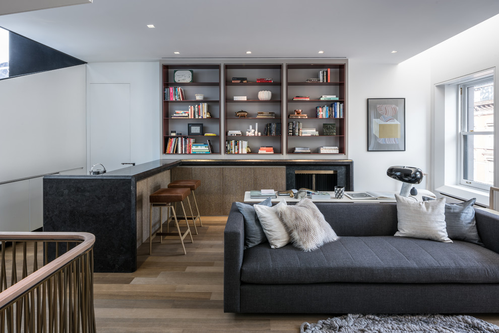 Immagine di un soggiorno contemporaneo di medie dimensioni e aperto con libreria, pareti bianche, pavimento in legno massello medio, parete attrezzata e pavimento marrone