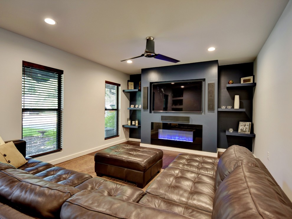 Mittelgroßes, Abgetrenntes Modernes Wohnzimmer mit grauer Wandfarbe, dunklem Holzboden, Gaskamin, gefliester Kaminumrandung und Multimediawand in Austin
