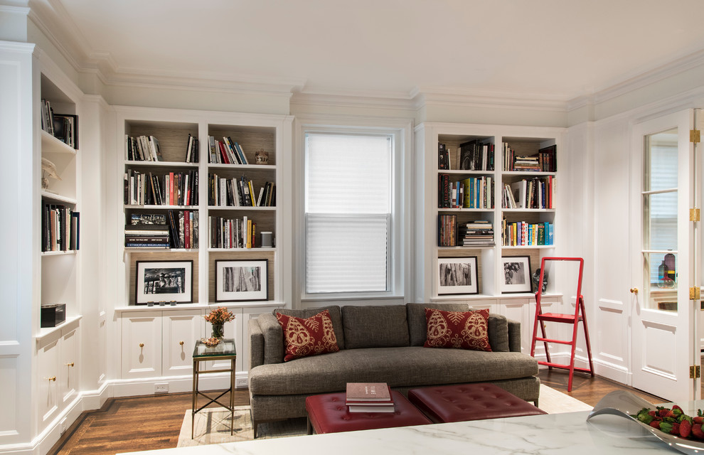 Ejemplo de sala de estar con biblioteca abierta tradicional renovada de tamaño medio con paredes blancas, televisor colgado en la pared, suelo marrón y suelo de madera en tonos medios