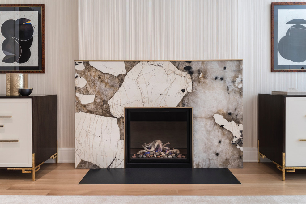 ニューヨークにあるお手頃価格の広いトランジショナルスタイルのおしゃれなLDK (ベージュの壁、淡色無垢フローリング、標準型暖炉、石材の暖炉まわり、テレビなし、ベージュの床) の写真