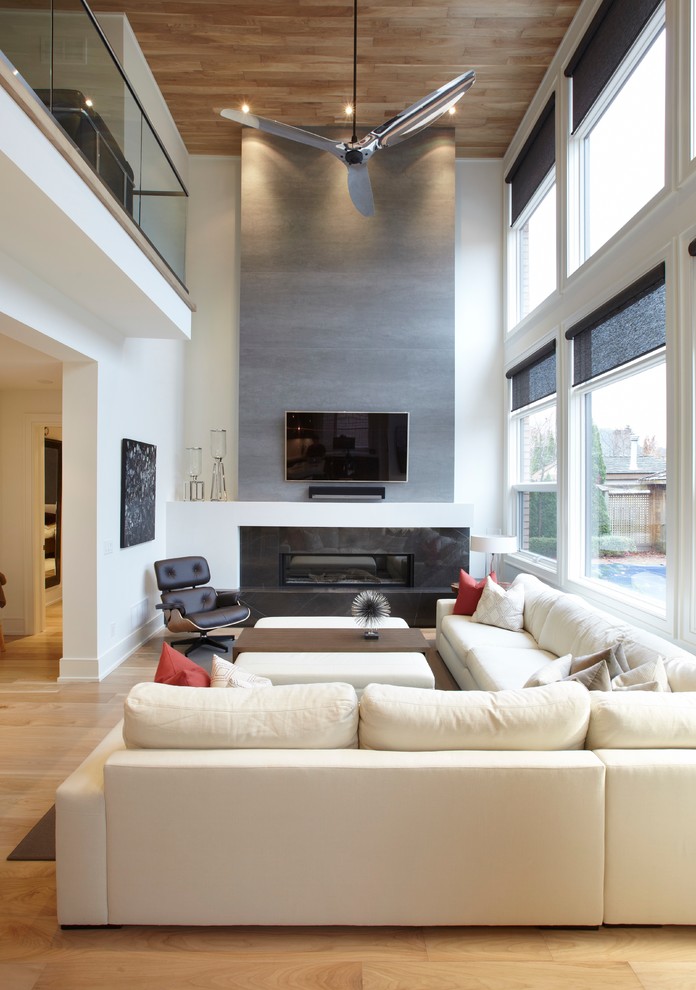 Foto de sala de estar abierta minimalista de tamaño medio con paredes blancas, suelo de madera clara, chimenea lineal, marco de chimenea de baldosas y/o azulejos y televisor colgado en la pared
