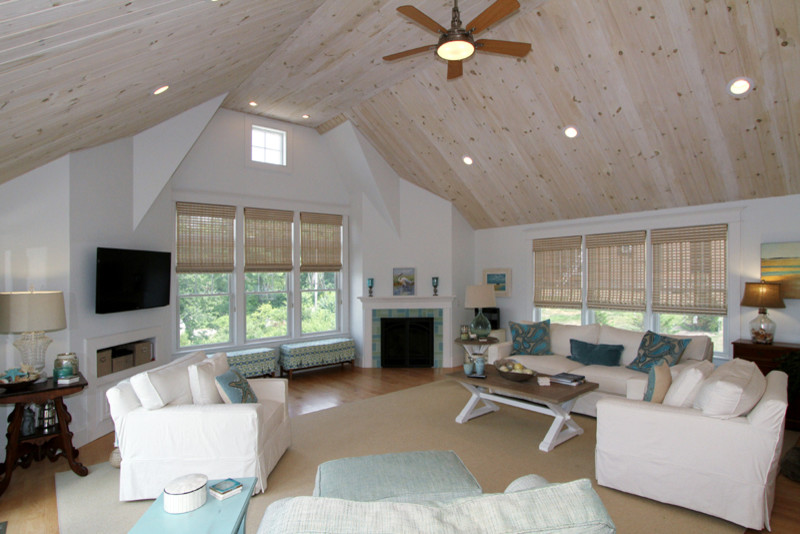 Пример оригинального дизайна: открытая гостиная комната в морском стиле с белыми стенами, светлым паркетным полом, стандартным камином, фасадом камина из плитки и телевизором на стене
