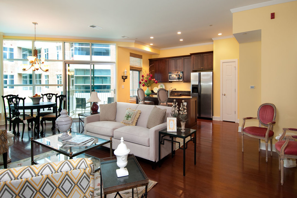 Aménagement d'une salle de séjour moderne ouverte avec un mur jaune et un sol en bois brun.