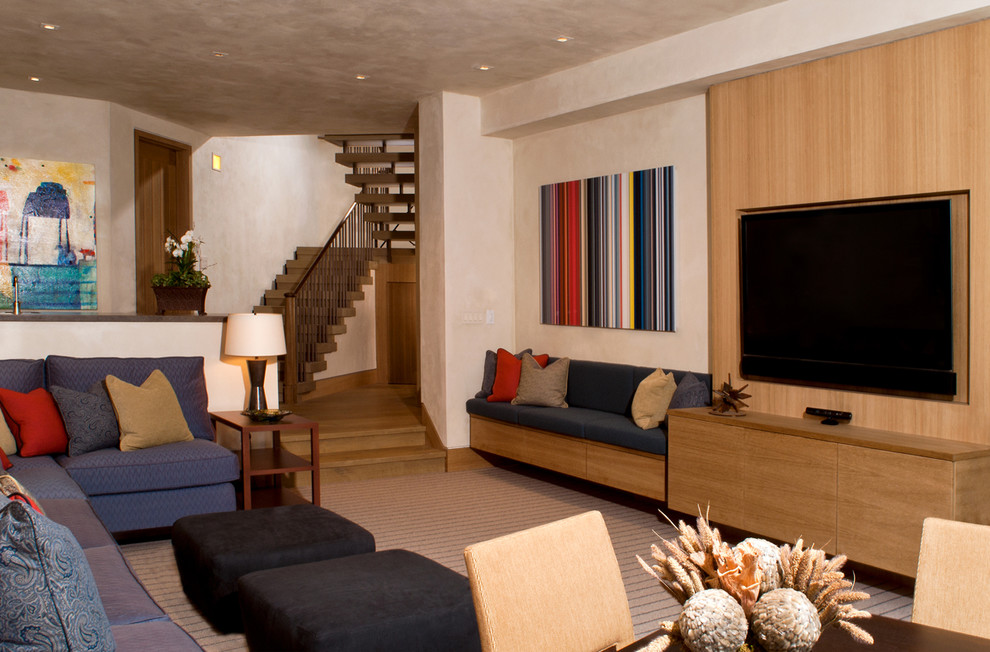 Ejemplo de sala de estar abierta actual grande con paredes beige, moqueta y pared multimedia