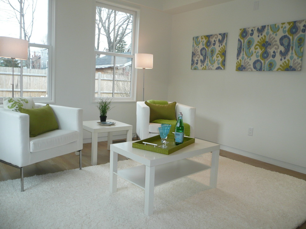 Immagine di un soggiorno design di medie dimensioni e chiuso con pareti bianche, parquet chiaro, nessun camino, nessuna TV e pavimento beige
