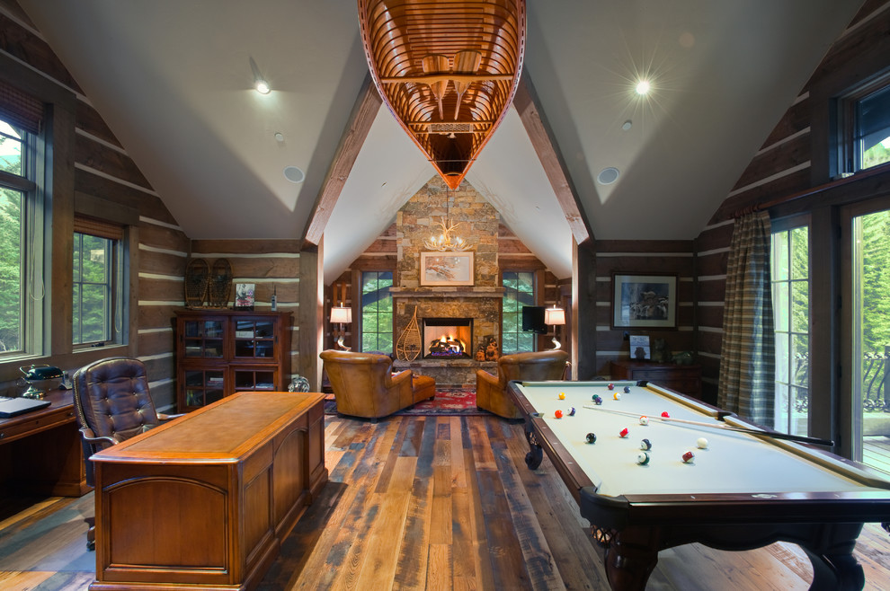 Family room - mid-sized rustic dark wood floor family room idea in Denver with brown walls, a standard fireplace, a stone fireplace and a wall-mounted tv