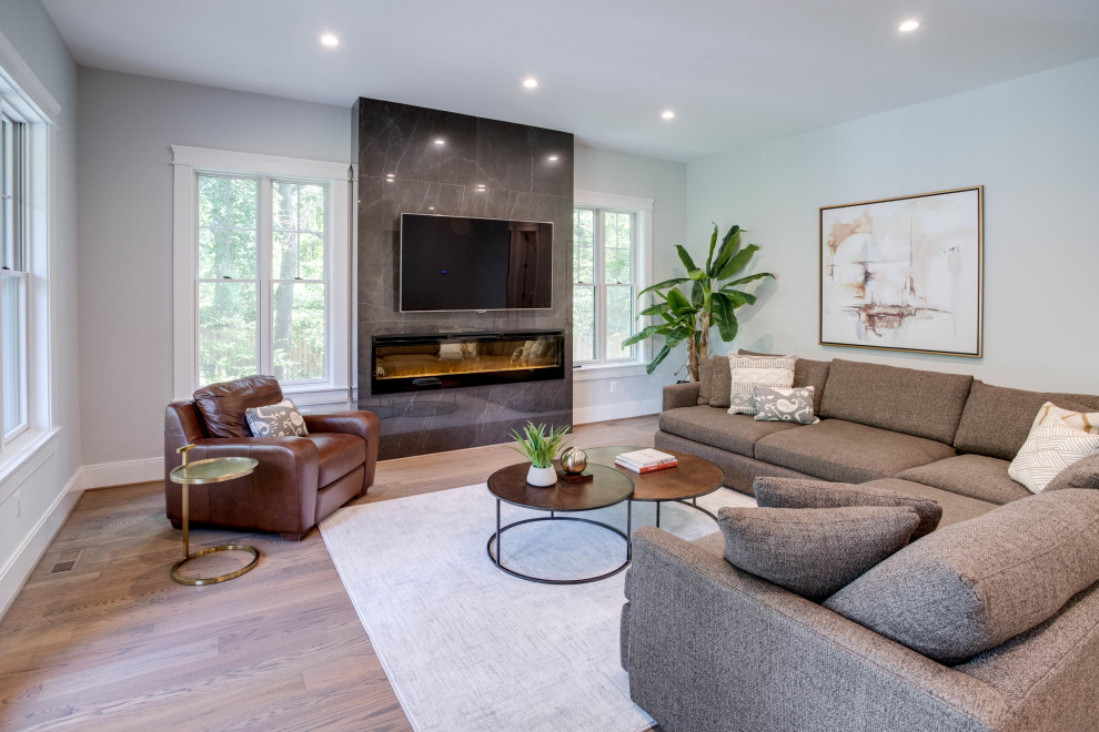 Inspiration for a medium sized contemporary enclosed games room in DC Metro with grey walls, light hardwood flooring, a ribbon fireplace, a tiled fireplace surround, a wall mounted tv and brown floors.