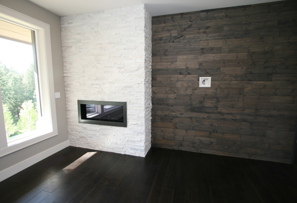 Inspiration pour une salle de séjour design de taille moyenne et ouverte avec un mur gris, parquet foncé, une cheminée ribbon, un manteau de cheminée en pierre et un téléviseur fixé au mur.