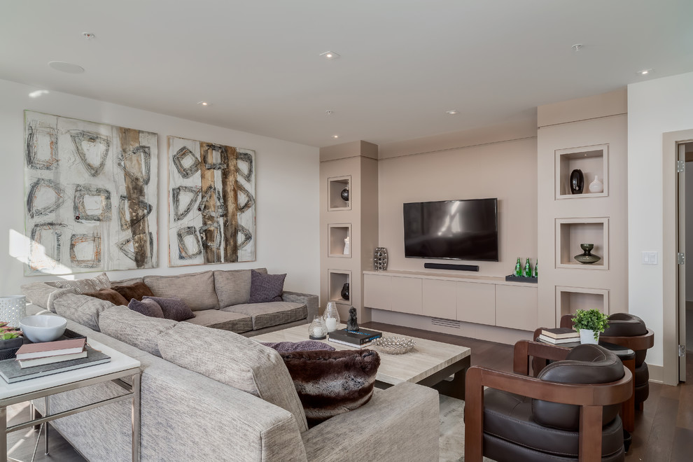 Cette photo montre une grande salle de séjour tendance ouverte avec un mur beige, un sol en bois brun et un téléviseur encastré.