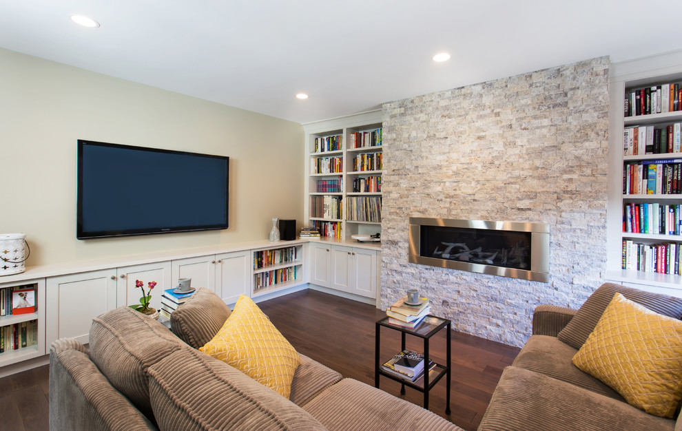 Exempel på ett litet klassiskt allrum med öppen planlösning, med ett bibliotek, beige väggar, mellanmörkt trägolv, en standard öppen spis, en väggmonterad TV och en spiselkrans i sten