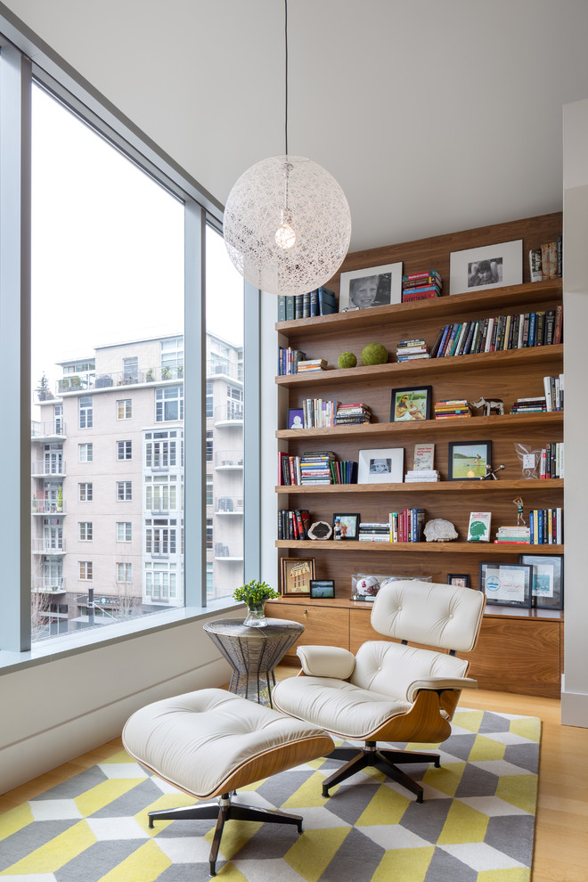 Foto di un soggiorno minimal con libreria, parquet chiaro e nessuna TV