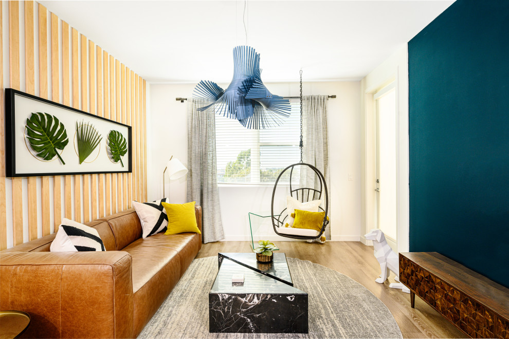 Пример оригинального дизайна: гостиная комната в современном стиле с синими стенами, паркетным полом среднего тона, коричневым полом, деревянными стенами и акцентной стеной