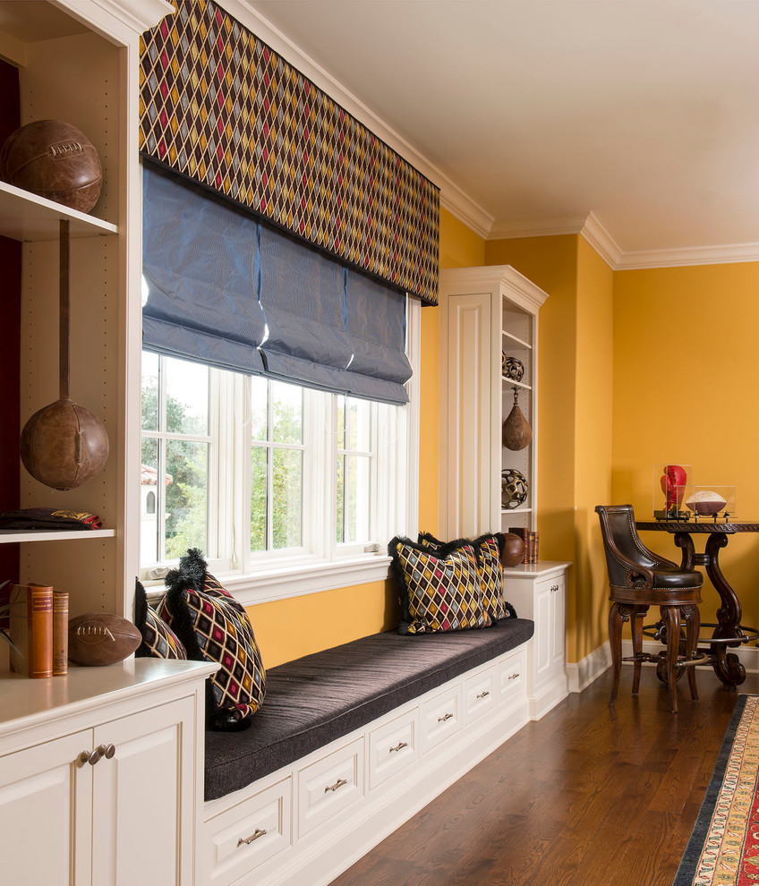 Inspiration for a large timeless medium tone wood floor and brown floor family room remodel in Other with yellow walls
